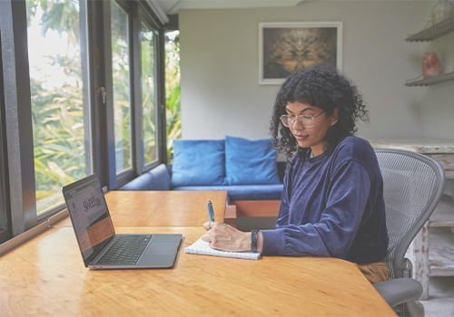 A woman running her solo business is writing down some notes