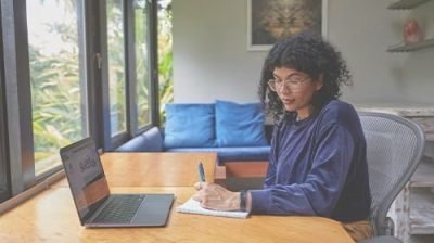 A woman running her solo business is writing down some notes