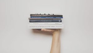 A hand is holding a some books